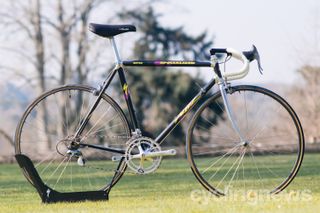 Side on view of a black and silver vintage road bike on a lawn