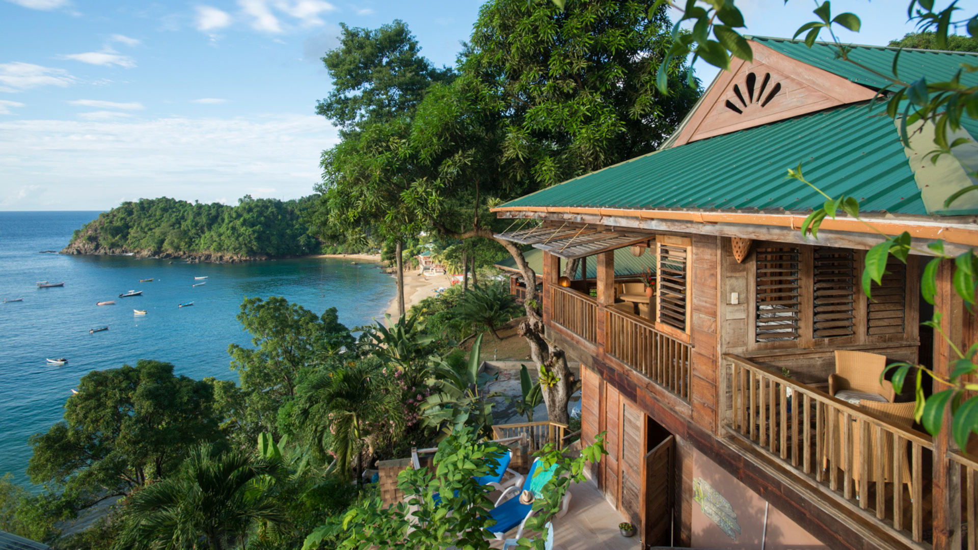The balcony of a wooden building at Castara Retreats, looking over the beach and sea