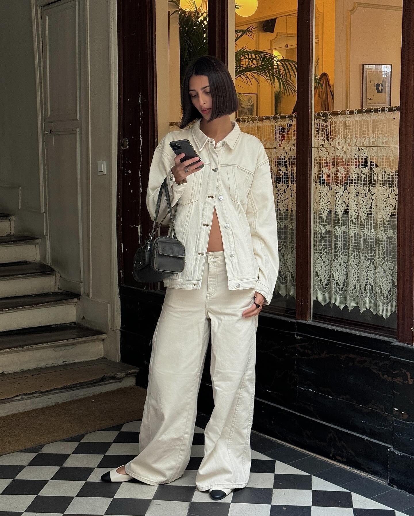 Woman wears white jeans and denim jacket look with white flat shoes