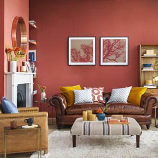 Earthy red living with rich brown leather Chesterfield-style sofa and upholstered footstool