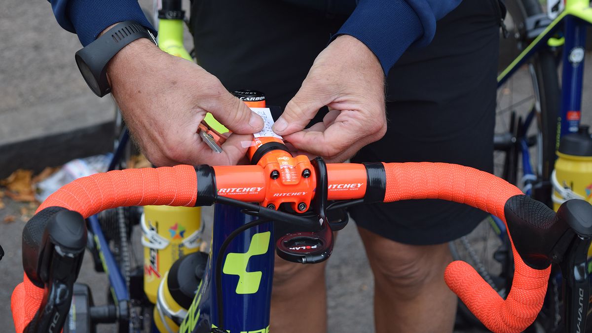 A Wanty-Groupe Gobert mechanic attaches race notes to each of the team's stems ahead of the stage start