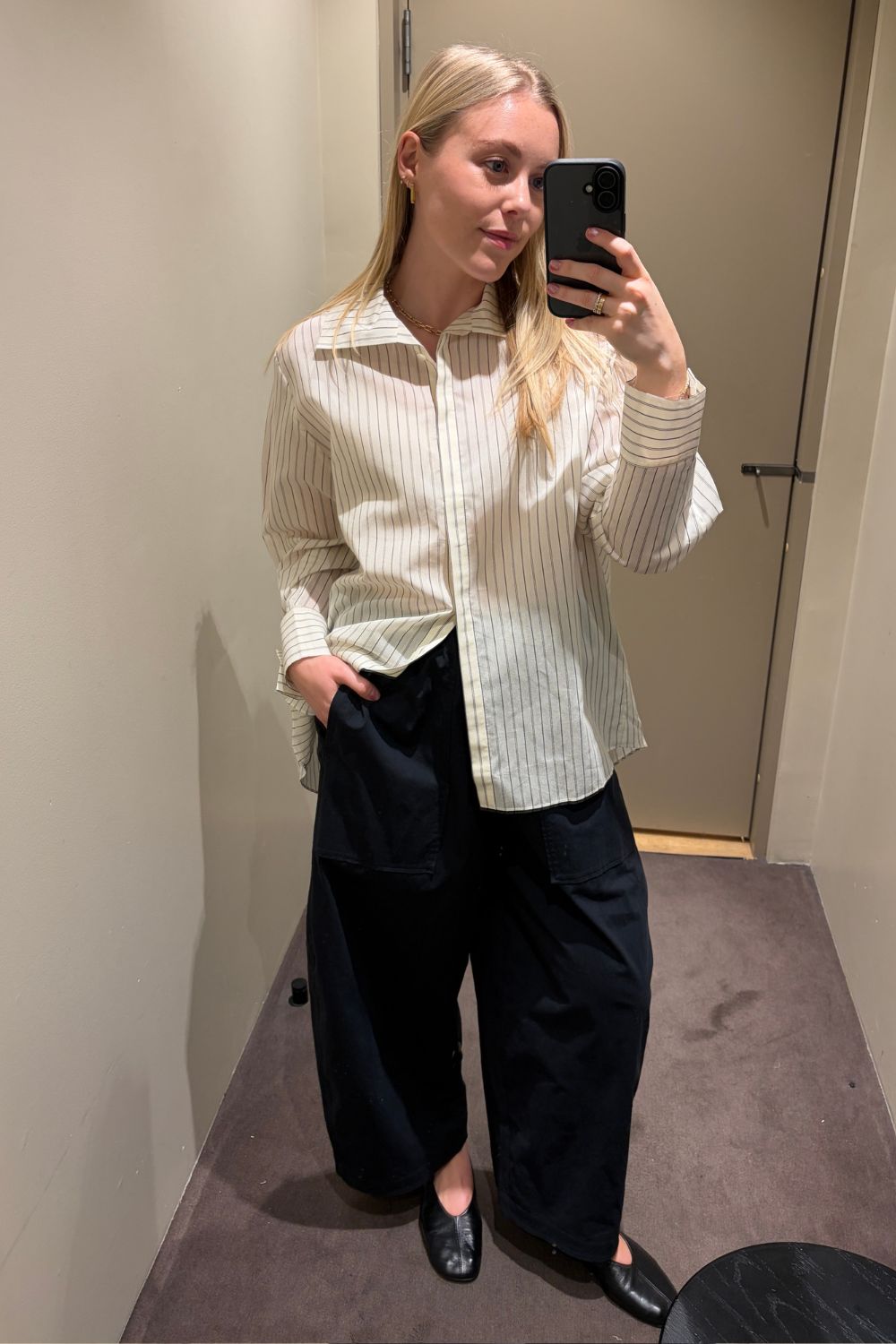 Woman wears striped shirt, cotton trousers and ballet flats