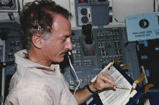 NASA astronaut Jeffrey Hoffman flew and read from the Torah on board the flight deck of space shuttle Columbia during the STS-75 mission, his fifth spaceflight, in 1996.
