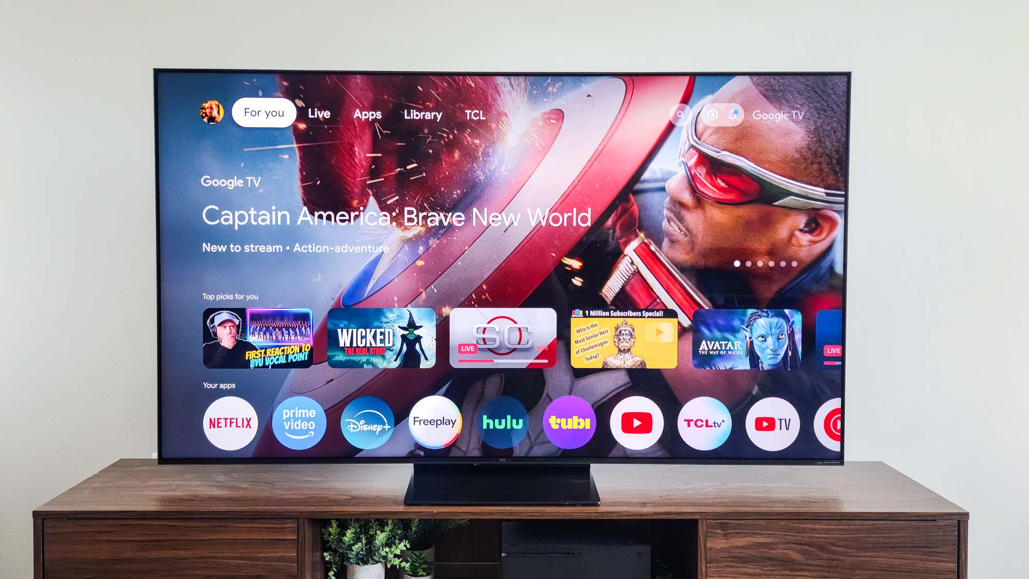 A TCL QM7K QD-Mini LED TV on a side table
