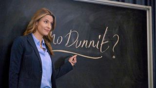 Jill Wagner stands inquisitively in front of a blackboard in Mystery 101.
