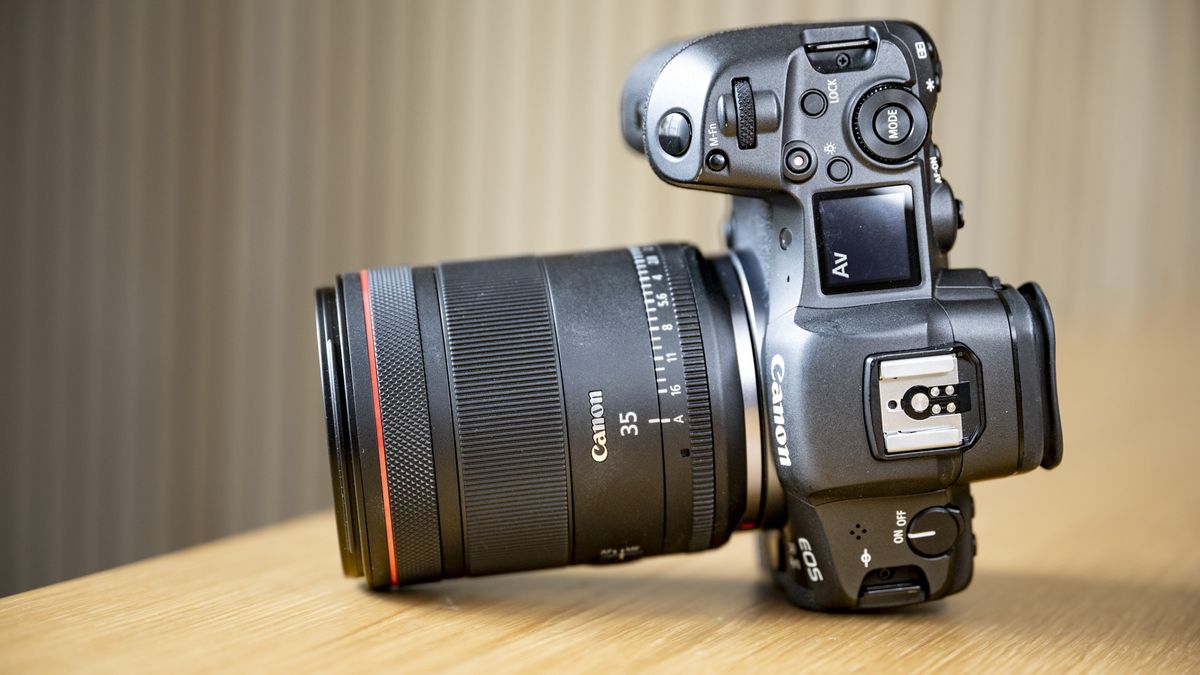 The Canon RF 35mm F1.4 lens on a wooden table, attached to a Canon EOS R5