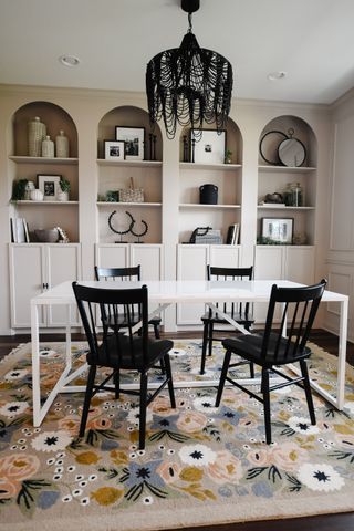 A dining room with four arched built in shelves