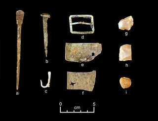 Artifacts discovered from the Neva shipwreck include (from left) part of a set of dividers, a nail, a fishhook, a buckle, sheet copper, gun flints and a musket ball.