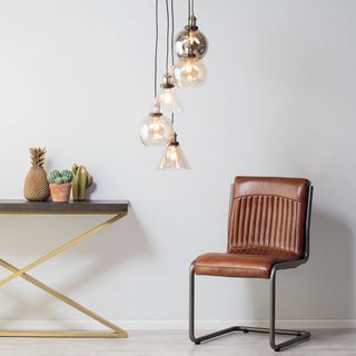 Cluster lighting suspended over a tan leather chair