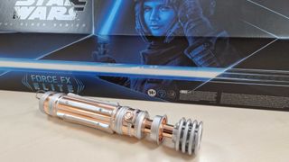 Leia Organa Force FX Elite Lightsaber hilt and box on a wooden table