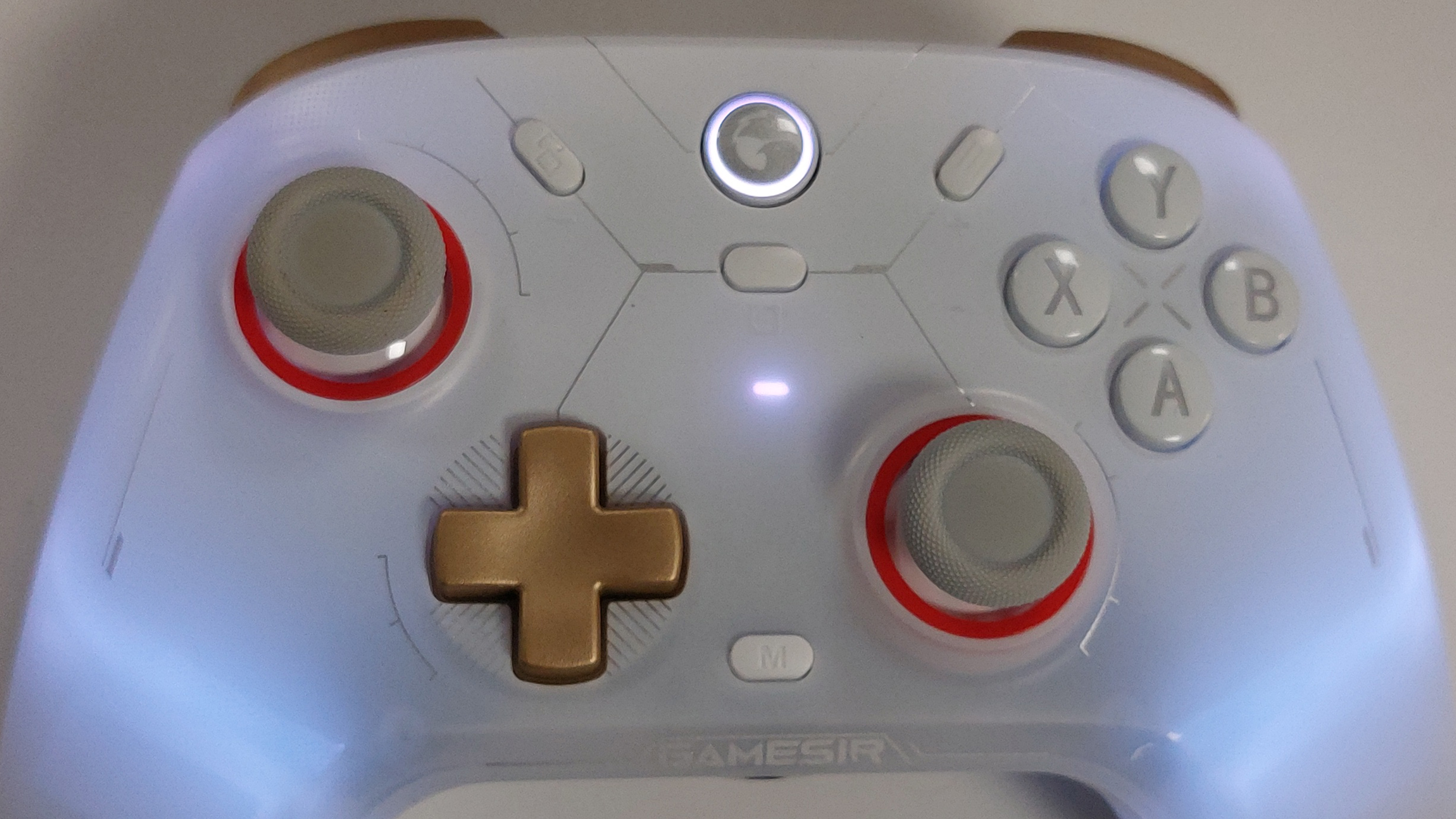 A close up on the GameSir Cyclone 2 controller in Phantom White, with the RGB-lights lit up and shining a pale light through the frosted plastic body of the gamepad.