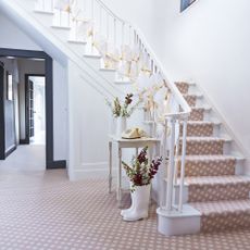 white walls with stairs and carpet on flooring
