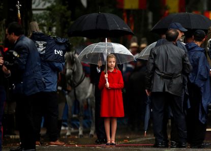 Spanish Princess Sofia holds an umbrella at the start of a military parade marking Spain's National Day in Madrid, Spain. 