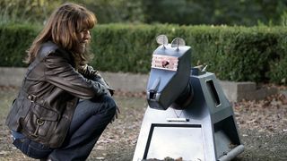 Sarah Jane Smith (Elisabeth Sladen) crouches next to K-9 in the Doctor Who episode "School Reunion"