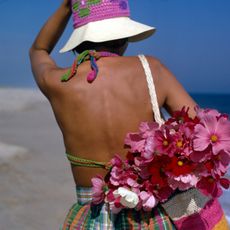 Woman on the beach in a crochet hat with a crochet bag