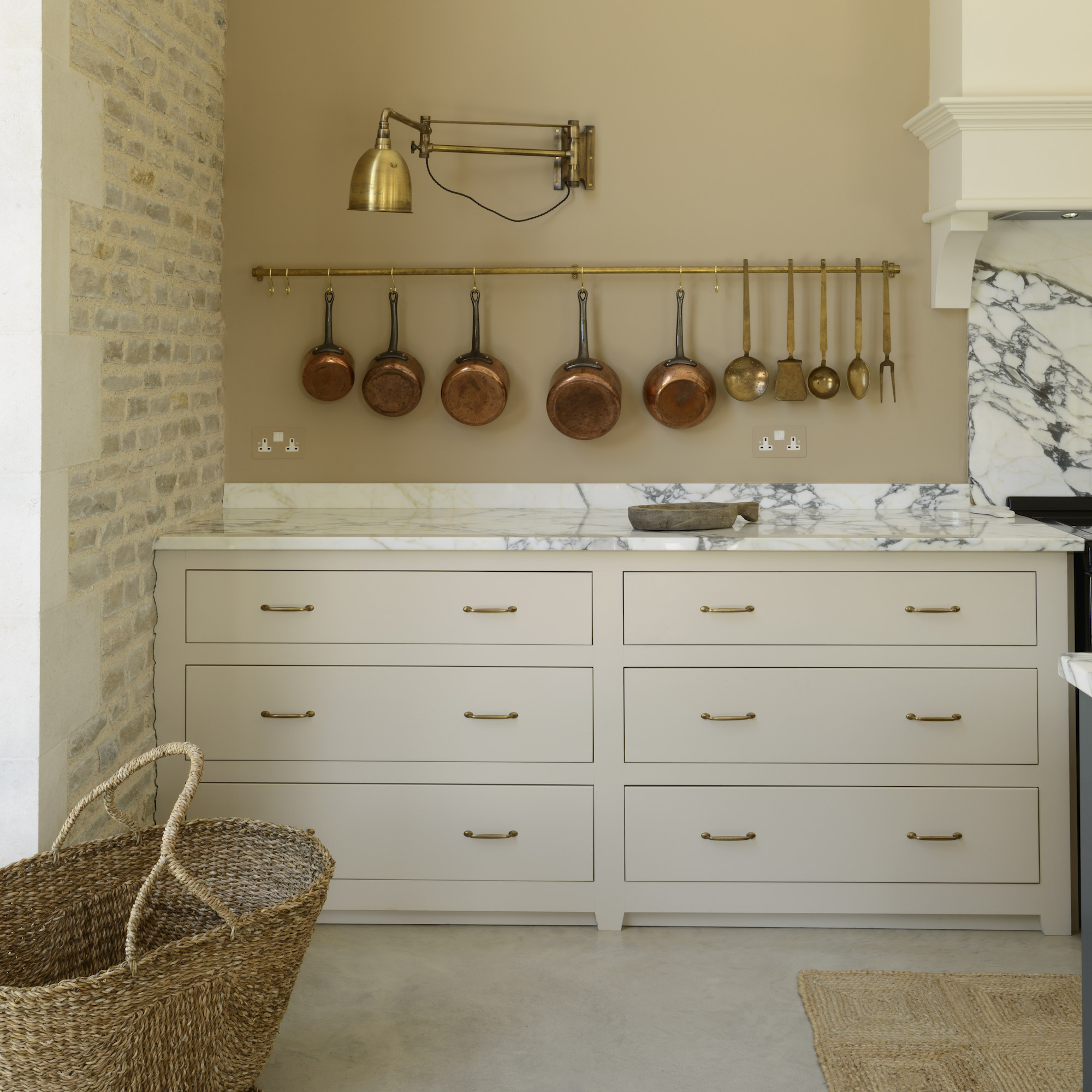 kitchen with taupe cabinets and copper pans on a rail