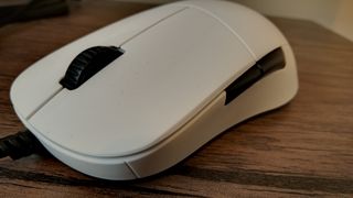 A white Endgame Gear XM1 gaming mouse on a wooden table