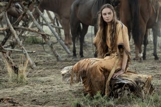 sarah lightfoot leon as abish pratt wearing sude clothes and sitting among horses in a still from american primeval