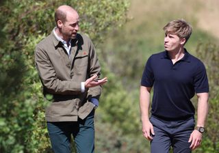 Prince William and Robert Irwin walking through woods talking