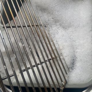 Kamado Maxi Ceramic Charcoal BBQ cleaning the grill in hot soapy water