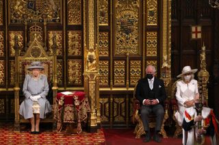 Queen Elizabeth II in the House of Lord's Chamber with Prince Charles, Prince of Wales and Camilla, Duchess of Cornwall seated (R) during the State Opening of Parliament at the House of Lords on May 11, 2021 in London, England