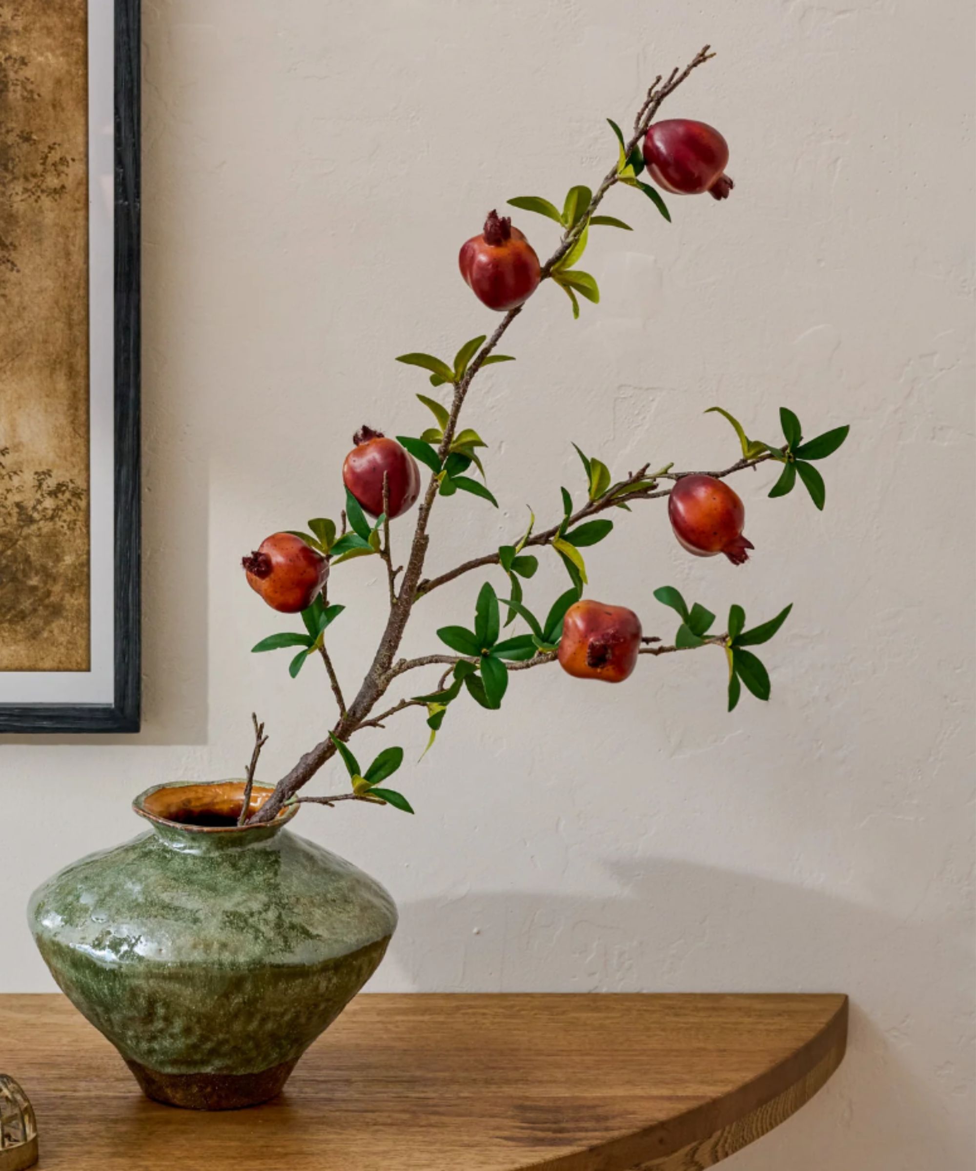 Etched green vase containing red stems