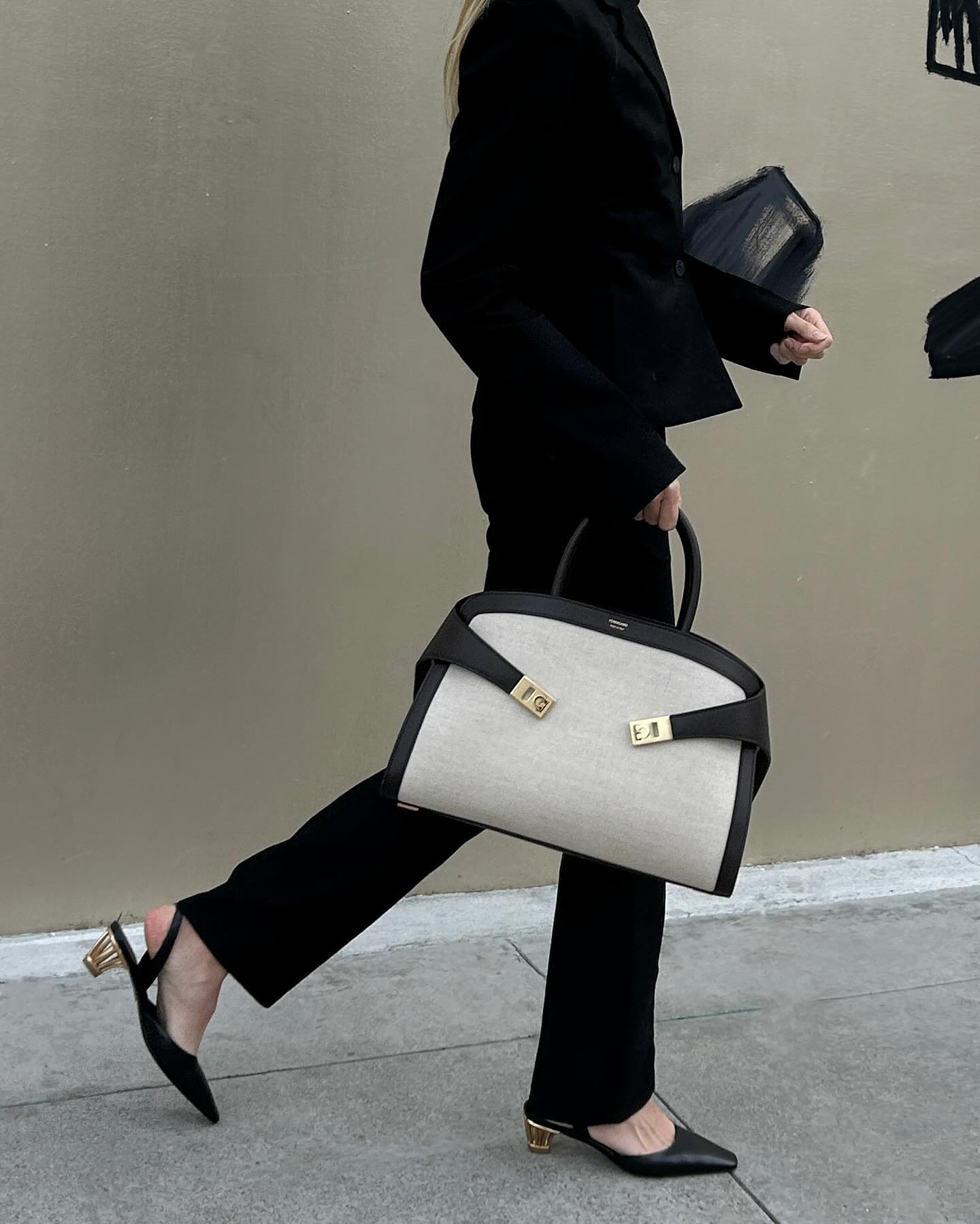 Jessie Andrews carrying a canvas-and-leather version of Ferragamo's Hug bag.