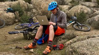 Guy working on his laptop on a mountainside