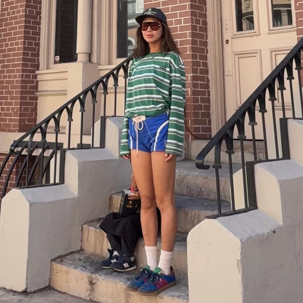 Woman in a stripe tee, shorts, and sneakers