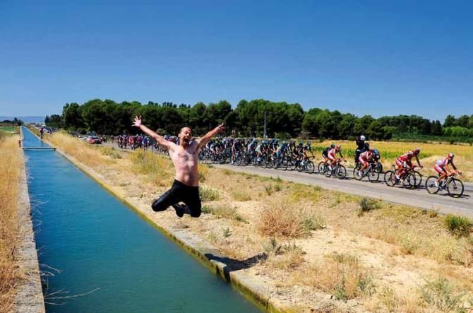 Tim de Waele's motorbike driver Kim Tiebergyn take the opportunity to cool off at the Vuelta