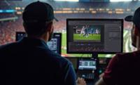Men viewing a screen in a sports stadium during a TV production