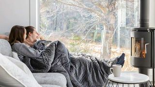 Couple on couch using Gravity Weighted Blanket