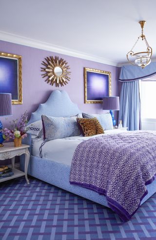 A bedroom with purple-lavender wall color