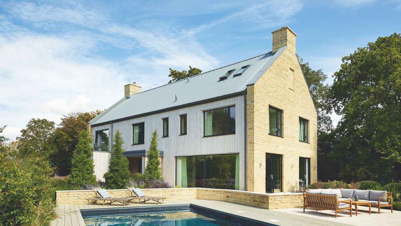 exterior of new build timber frame and stone house with swimming pool