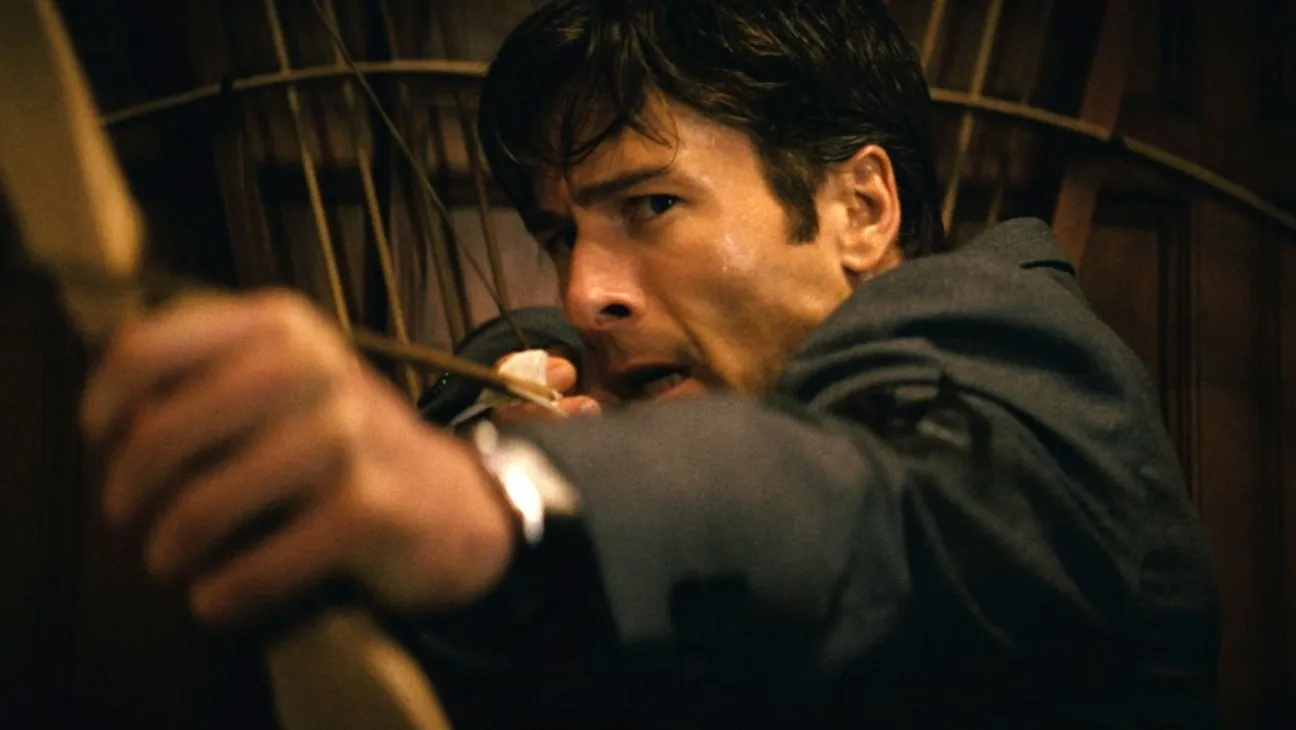 Glenn Powell with a bow and arrow