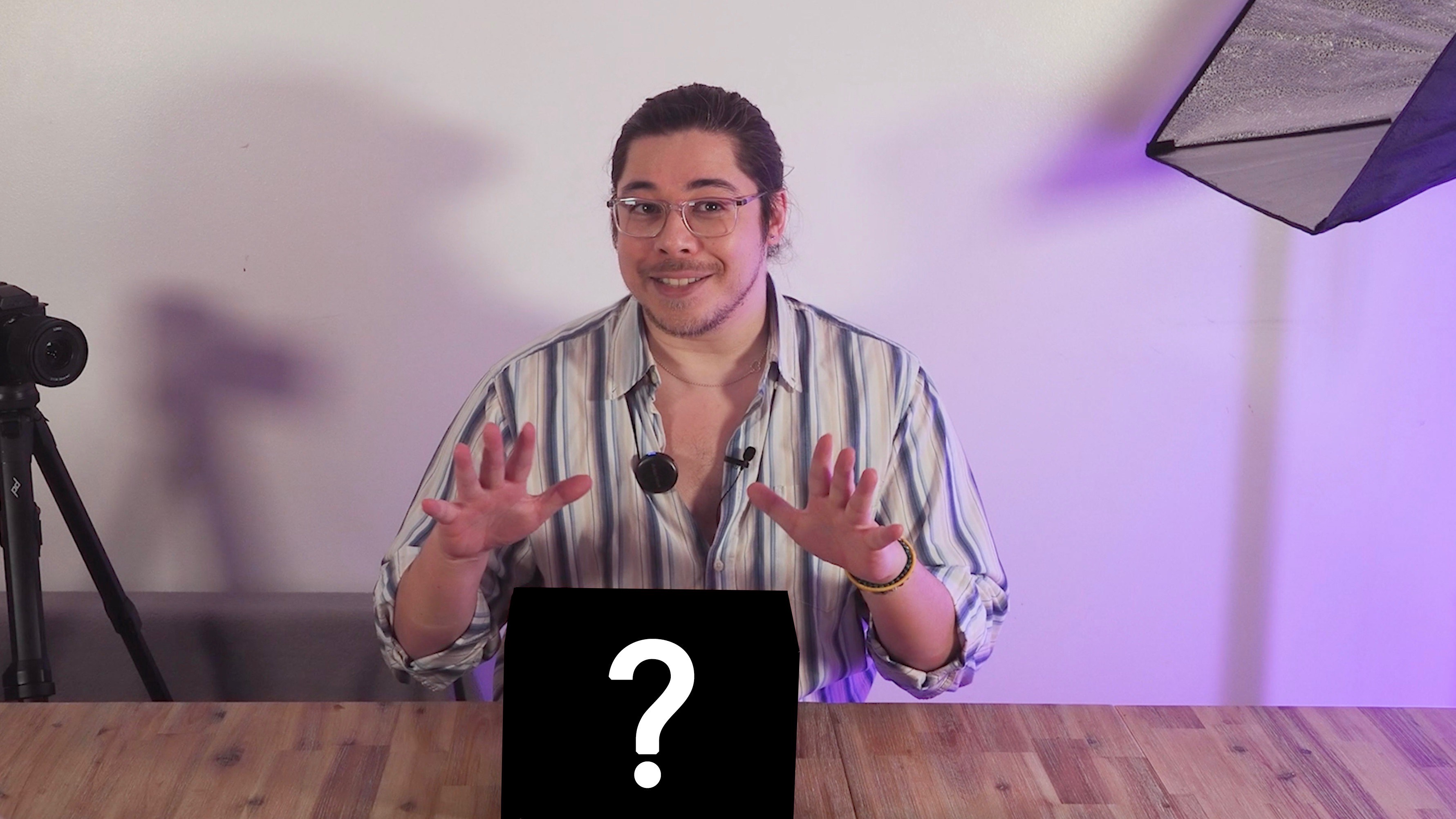 James Artaius standing at a desk with a mystery box bearing a "?" symbol
