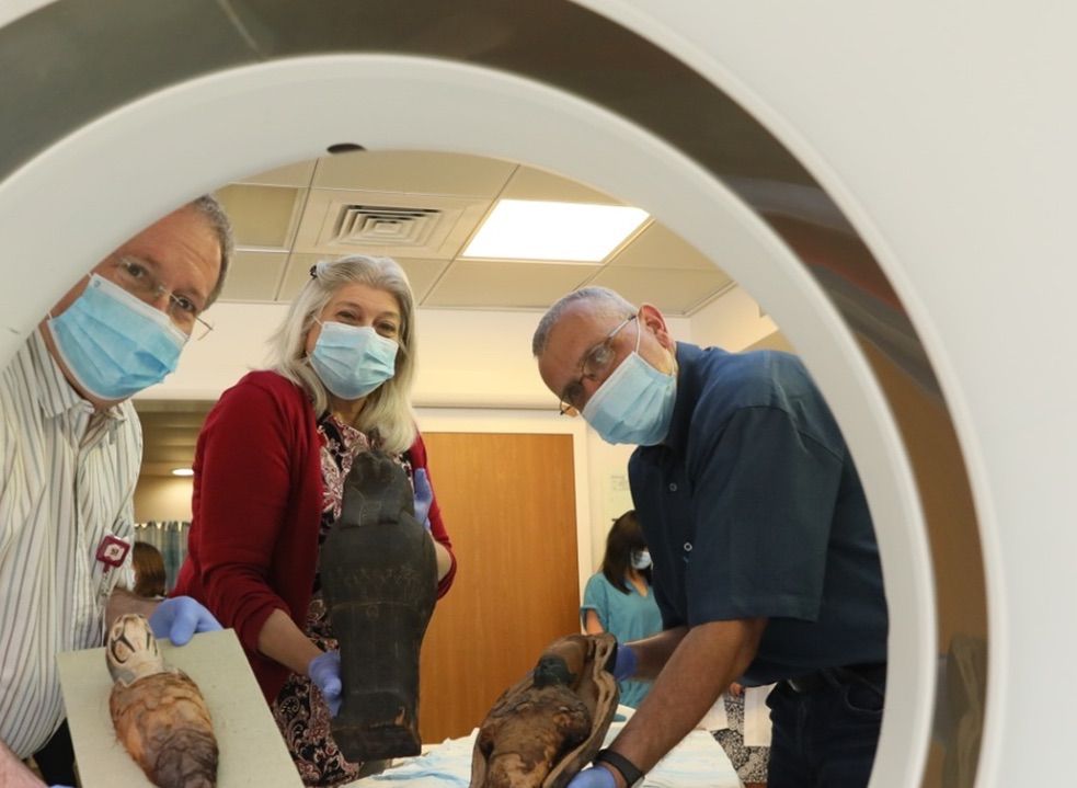 Dr. Marcia Javitt (center) and colleagues hold the mummies and sarcophagi.