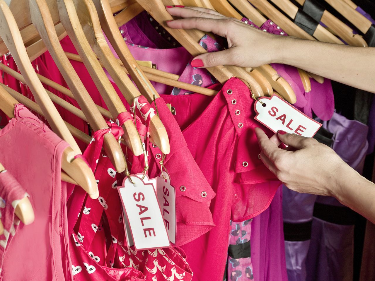 A series of fashion items on a rail with sale tags