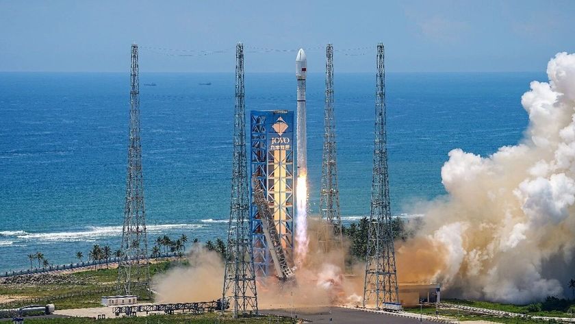A white Long March 12 rocket lifts off against the backdrop of a rich blue sea.