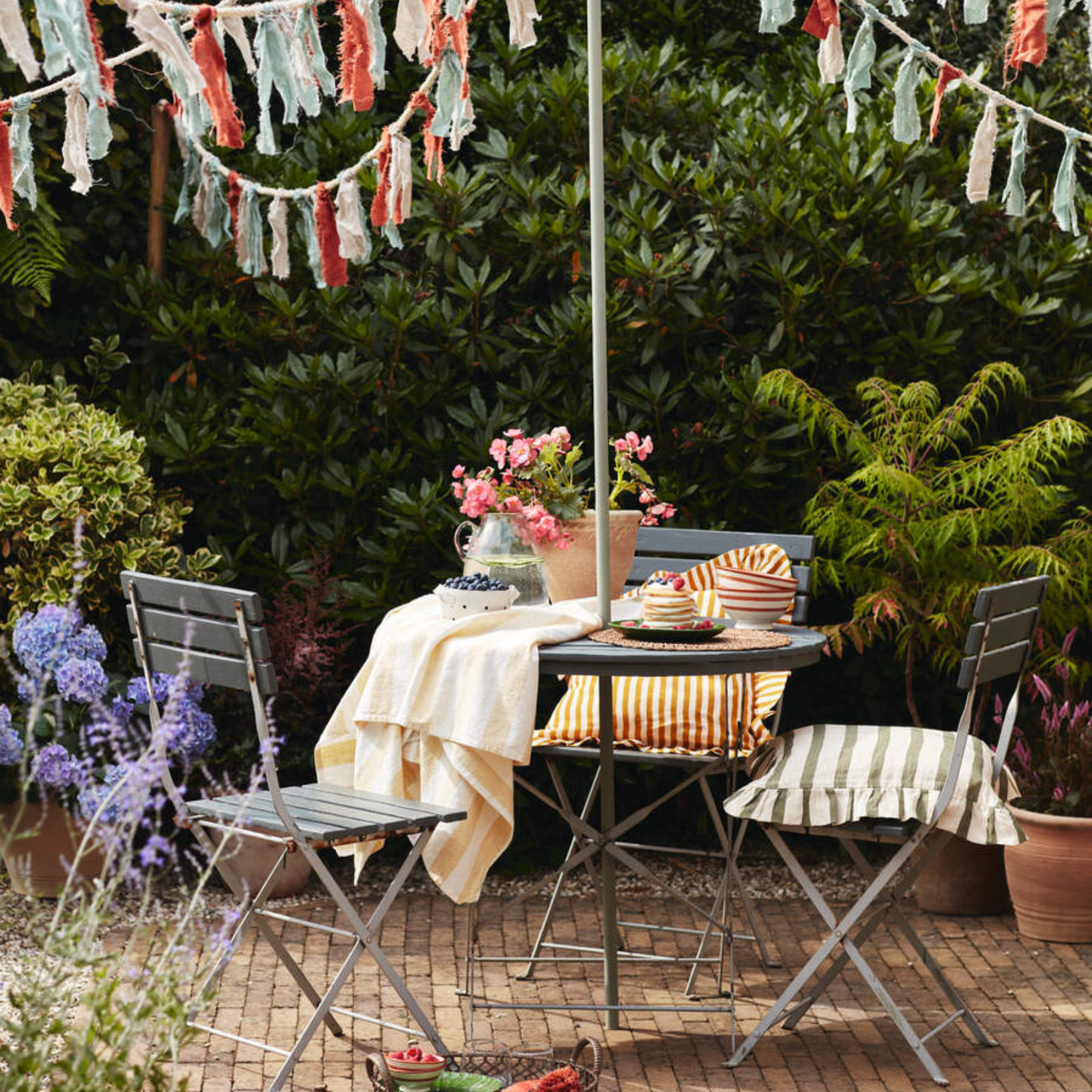 Boho patio with garden table and chairs, and bunting.