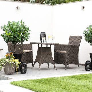 Garden with white walls and rattan furniture