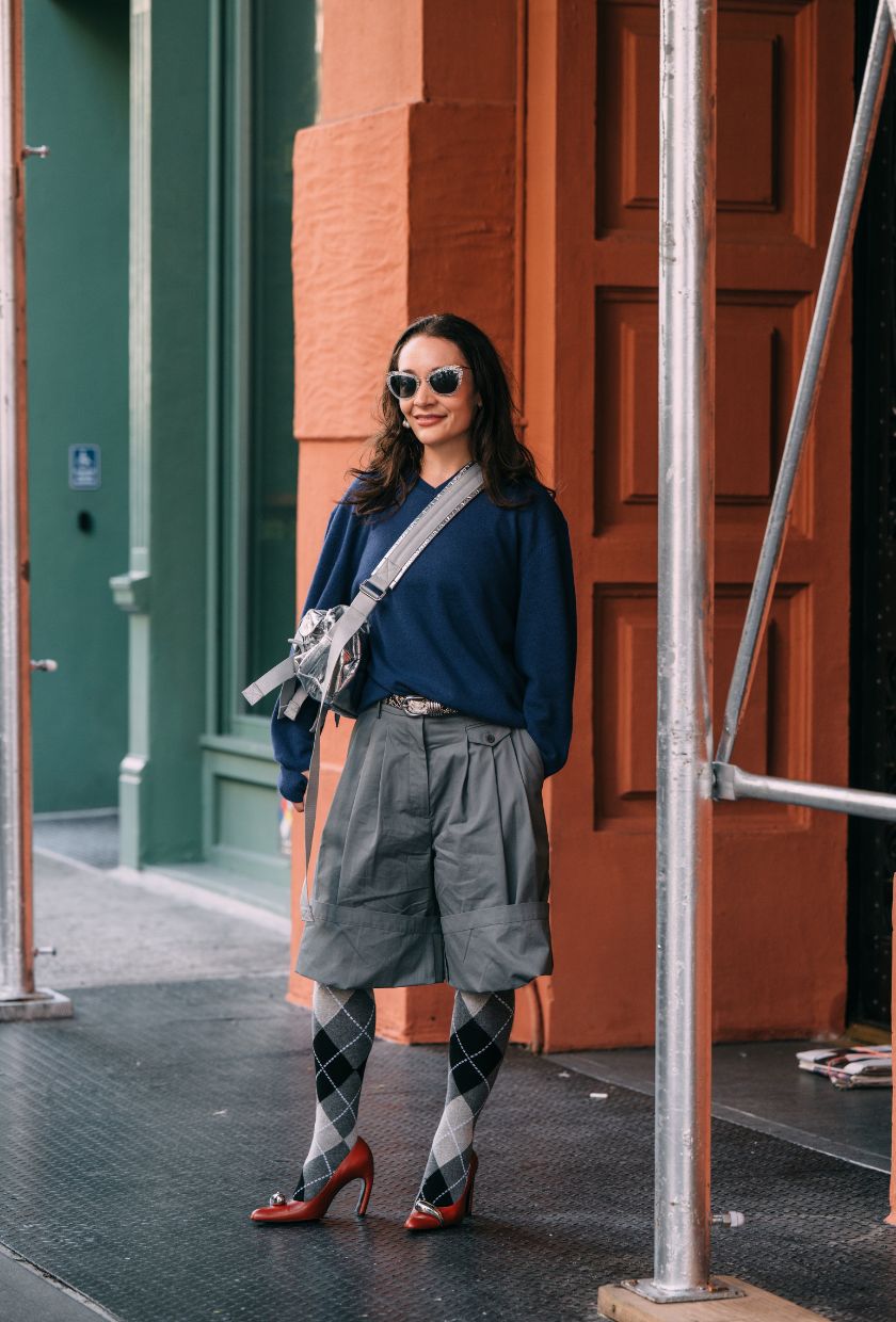 An image of @oldloserinbrooklyn wearing an orange coat with argyle tights.