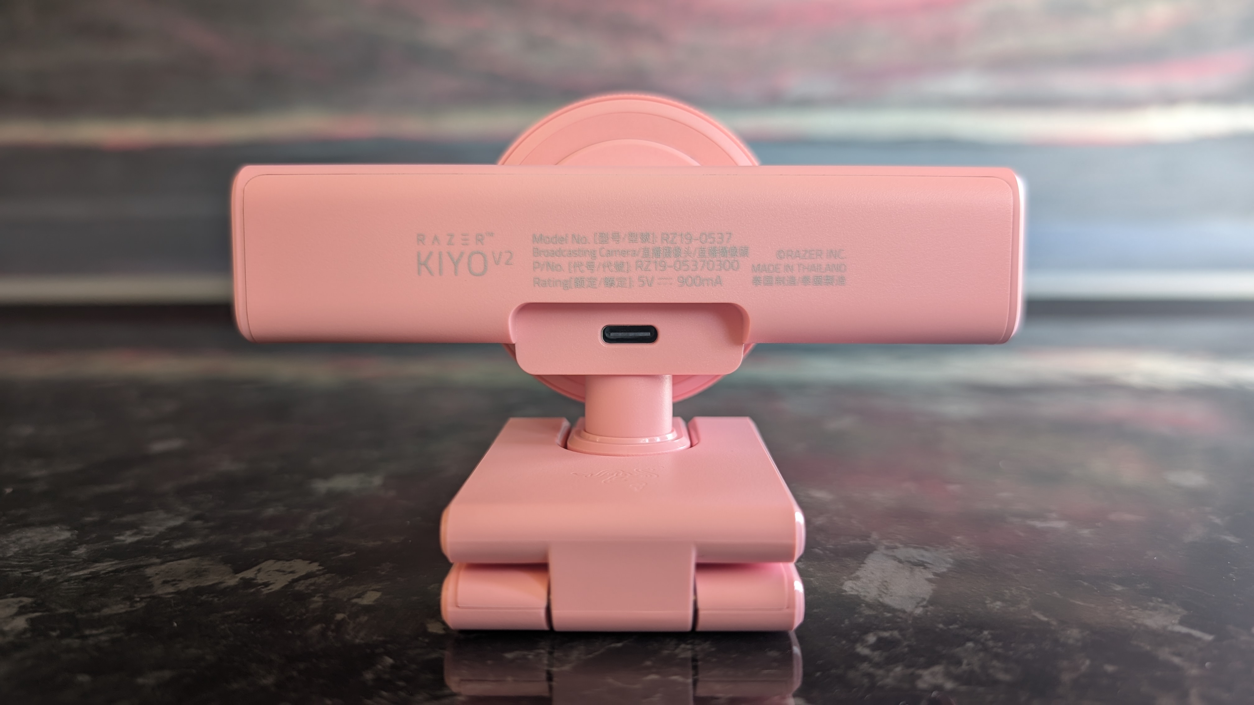 The Razer Kiyo V2 webcam pictured on a dark marble worksurface.