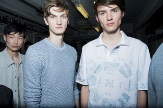 Three male models wearing clothing by Pringle of Scotland in light shades.