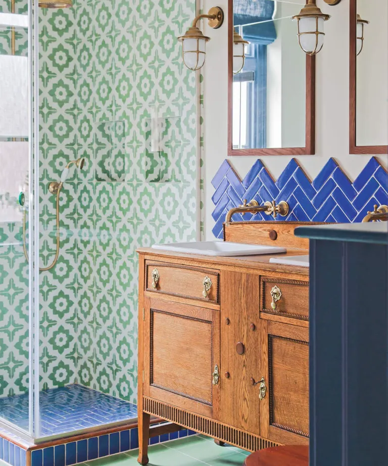 Shower room decorated with navy blue and green tiles with wooden vanity