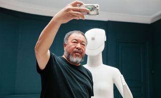 artist taking a selfie with one of his sculptures