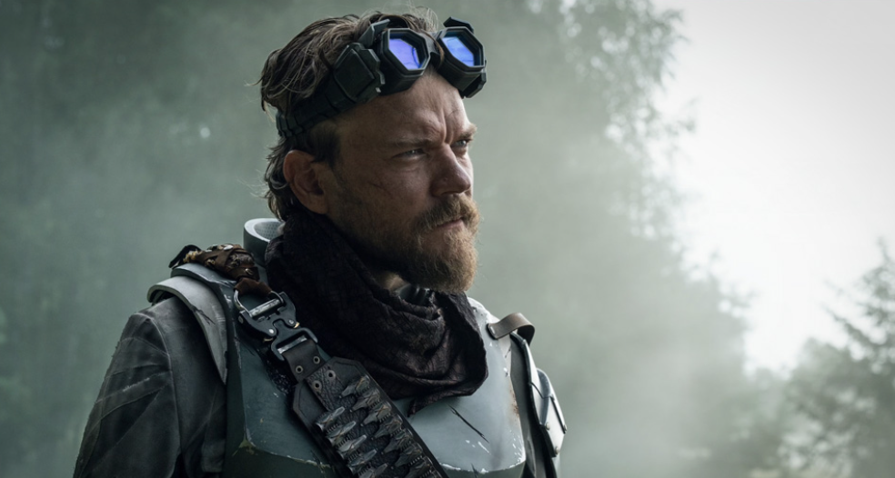 a bearded man from the future wearing a bandolier and goggles
