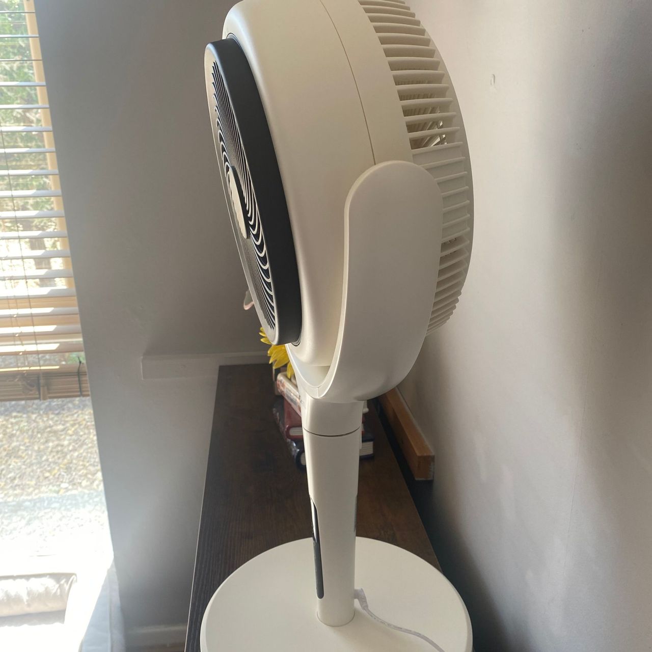 Maximum downward tilt of the AirCraft LUME Quiet Air Circulator Fan on wood sideboard in a taupe coloured room