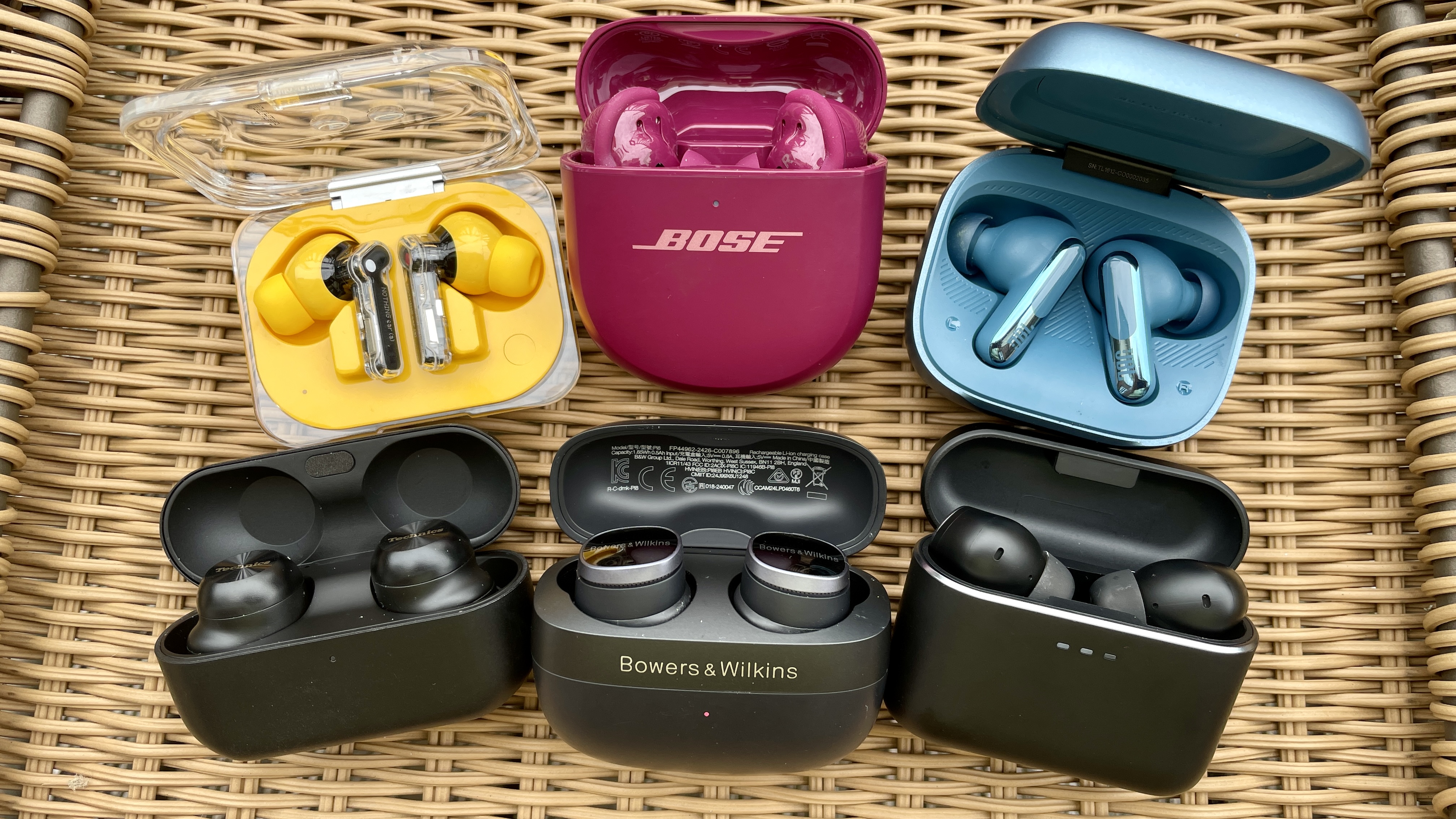 A selection of earbuds (Nothing, Bose, JBL, Technics, Bowers &amp; wilkins and Cambridge) in a wicker basket