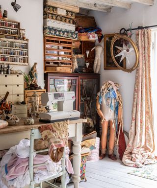 sewing room in cottage filled with vintage cabinets and drawers, vintage fabrics and boxes